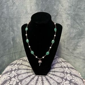 green and gold necklace with pearls and palm tree